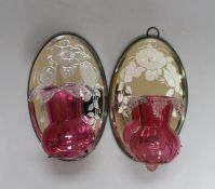 A pair of Victorian style cranberry glass wall lights with oval mirror back plates