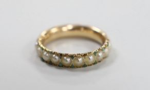 An antique yellow metal and split pearl set full eternity ring with green cabochon spacers, size K/