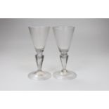 A pair of Continental facon de Venice wine glasses, first half 18th century, round funnel bowls