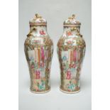 A pair of Chinese famille rose Canton baluster jars and covers with lion dog finials, 32cm high