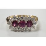 A modern 18ct gold, ruby and diamond set triple cluster ring, size L, gross weight 3.3 grams.