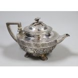 A George III engraved silver squat circular teapot, with foliate decoration and rose finial, by John