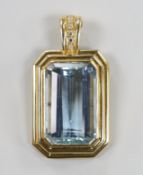 A modern 14ct gold and single stone emerald cut aquamarine set octagonal pendant, with six stone