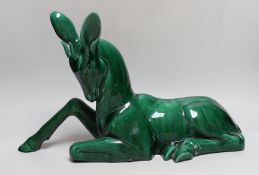 A French Art Deco large green glazed ceramic model of a seated deer, 50cm wide