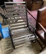 A pair of cast metal slatted wood rocking garden chairs, width 62cm, depth 86cm, height 88cm