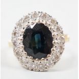 A 1970's? 18ct gold, single stone oval cut sapphire and illusion set diamond cluster ring, size O/P,