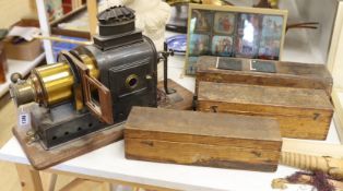 A magic lantern and three wooden boxes of slides and a panel of coloured slides