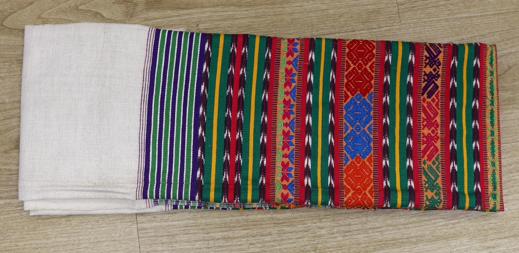 A Guatemalan shawl, the lower part polychrome woven with chevrons, stylised flowers and geometric