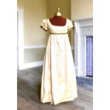 A lady's Regency style day dress in cream silk with black lace trim (lacing at back). Ex London