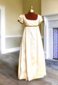 A lady's Regency style day dress in cream silk with black lace trim (lacing at back). Ex London