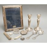 Sundry silver and white metal including a pair of modern candlesticks and a similar photograph