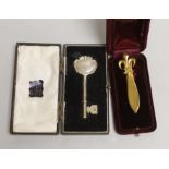 A silver presentation key and gilt metal French tie pin, both cased