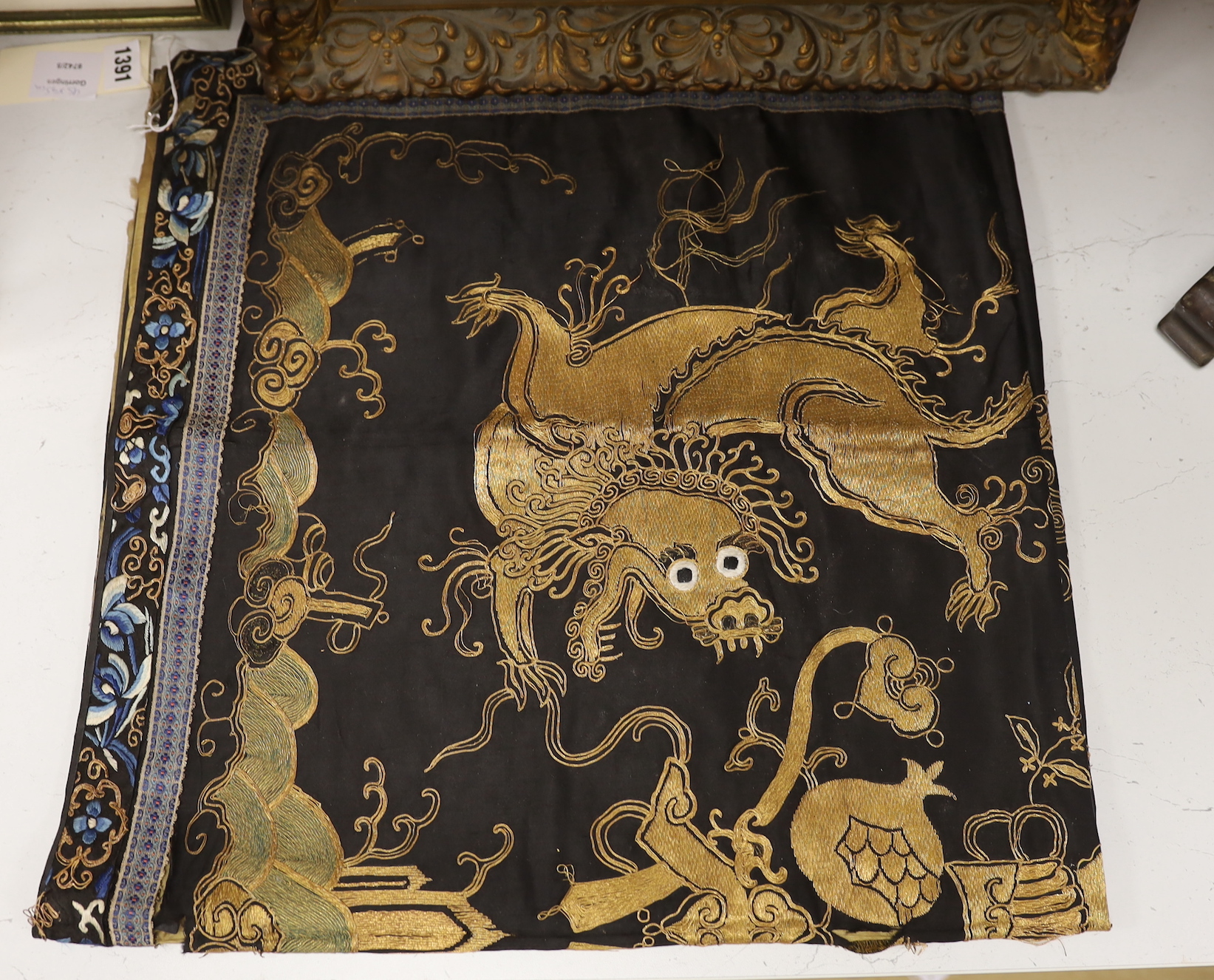 A 19th century Chinese dark blue ground panel, gilt thread embroidered with a pair of celestial