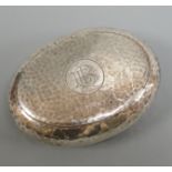 An Edwardian hammered silver oval tobacco box, William M. Hayes, Birmingham, 1908, 86mm.