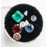 Eight assorted unmounted cut gemstones, including emerald and diamond.