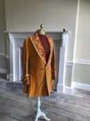 A man's 19th century smoking jacket, mustard velvet, with brocade lapels and cuffs. Ex Royal Opera