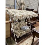 A vintage metal garden swing seat with printed floral covers, width 170cm, depth 104cm, height