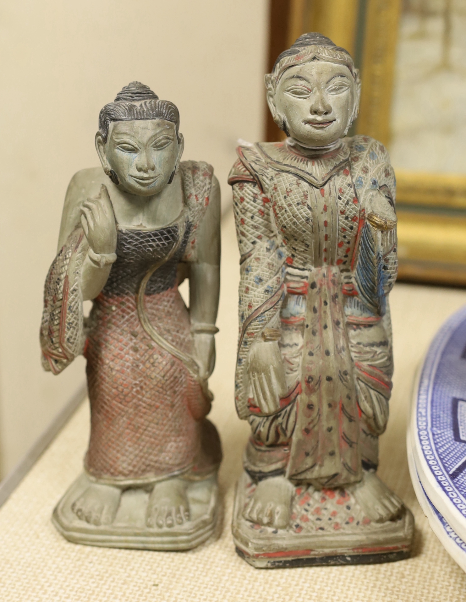 An Indonesian hand painted calendar and two similar figures, tallest 21cm