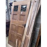 A panelled oak door with inset stained glass panels, width 78cm, height 194cm, another panelled