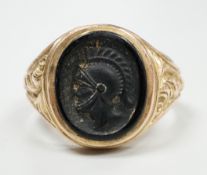 A 1970's 9ct gold and black onyx? set signet ring, carved with the bust of a Roman soldier, size
