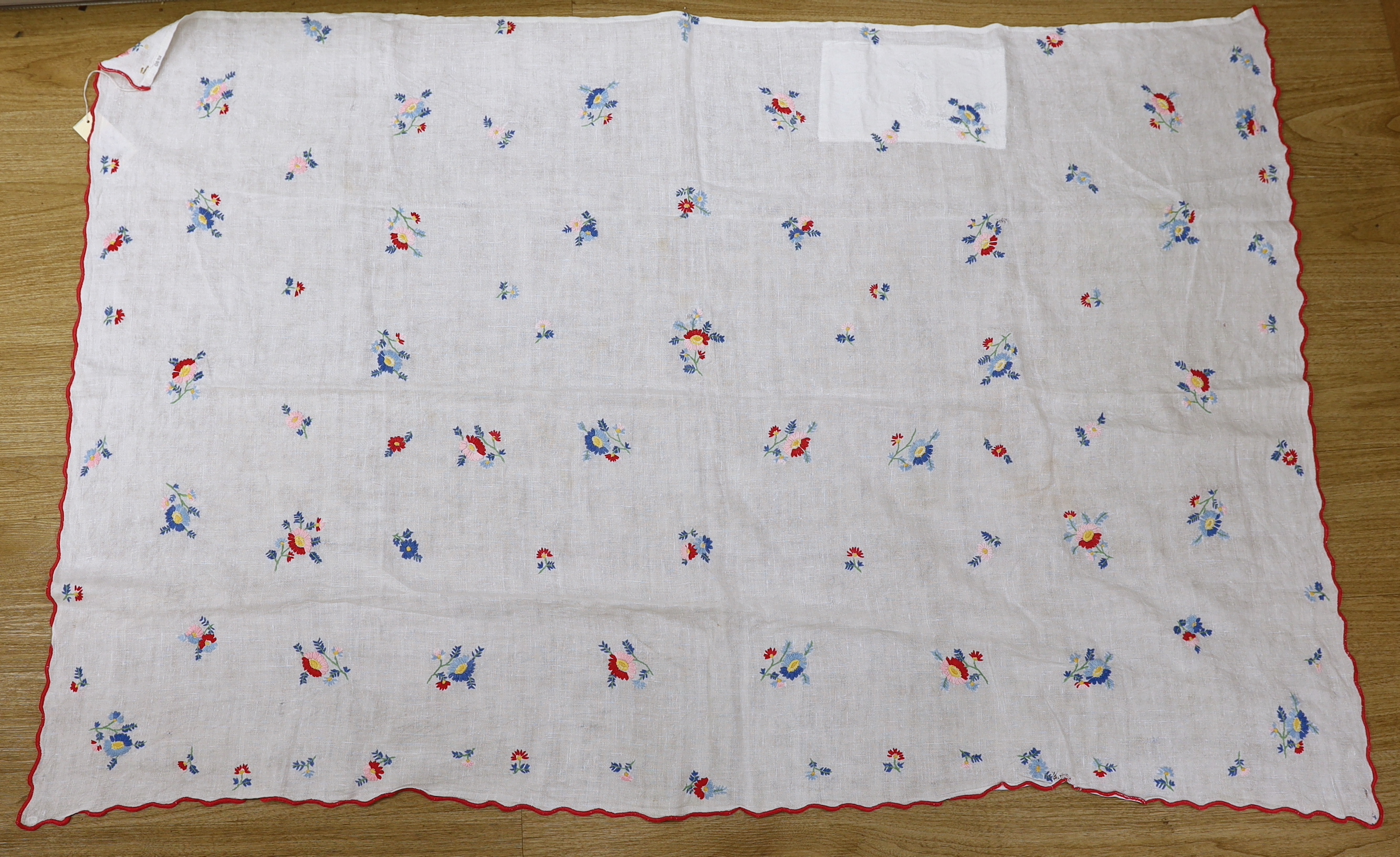 A 20th century woven linen panel, hand embroidered with scattered floral polychrome sprigs and a