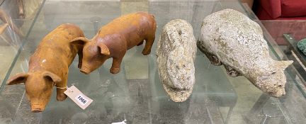 A pair of cast metal garden pig ornaments and a cast stone cat and rabbit ornament, largest length