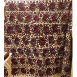 An exceptionally large Suzani hanging, embroidered with rows of stylised aubergine flower heads, the