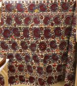 An exceptionally large Suzani hanging, embroidered with rows of stylised aubergine flower heads, the