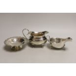 A George V silver cream jug, a George V silver sauceboat and a George V silver circular scale work