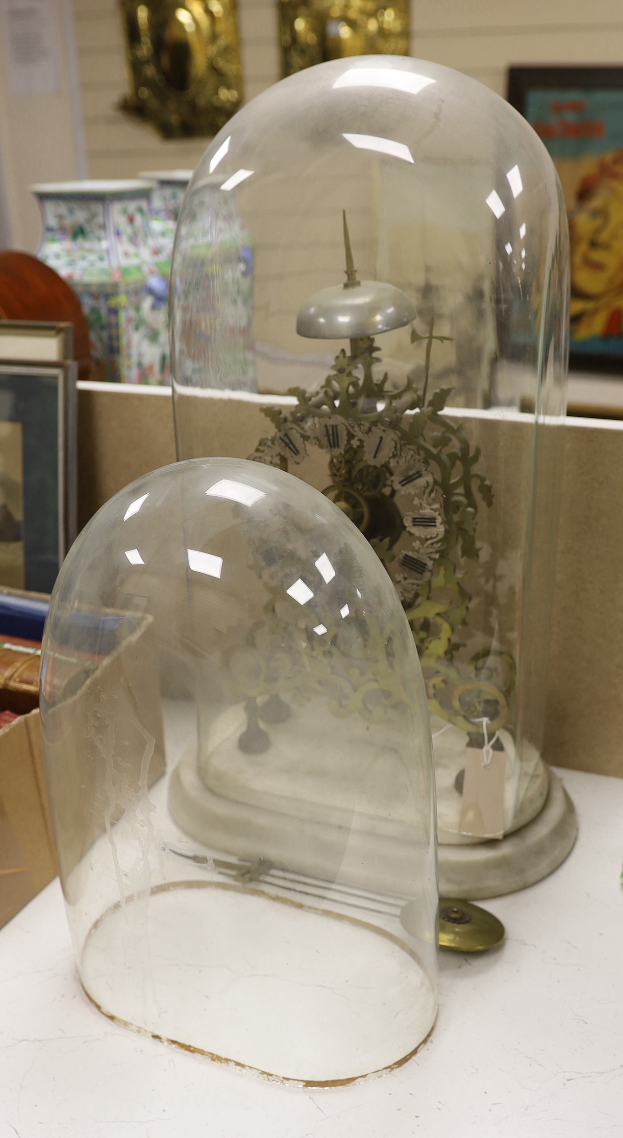 A Victorian skeleton clock and two glass clock domes
