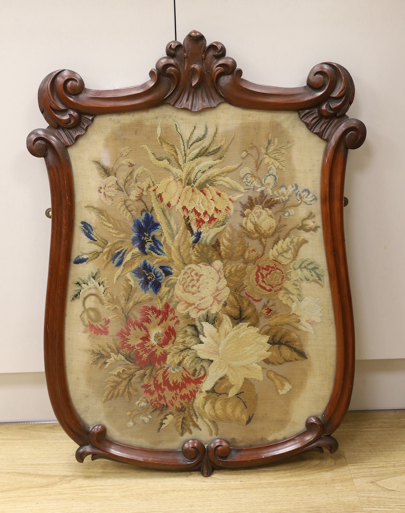 A Victorian petite point embroidered panel, in shield shaped mahogany frame (ex pole screen), 80cm