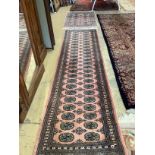 A Bokhara peach ground runner, 310 x 83cm together with a similar rug