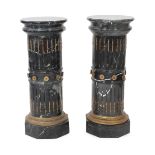 A pair of ornate variegated green marble columns, the fluted stems inset with gilt harebell motifs