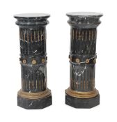 A pair of ornate variegated green marble columns, the fluted stems inset with gilt harebell motifs