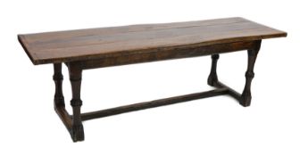 A Charles I oak refectory table, c.1630, the triple plank top with cleated ends, the four unusual