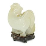 A Chinese pale celadon jade chicken group, 19th century, the hen and the cockerel both grasping a