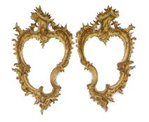A pair of 19th century carved giltwood wall mirrors in the Rococo style, of asymmetrical form with
