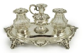 An ornate Victorian silver oval inkstand, by Henry Wilkinson & Co, with foliate scroll border, two