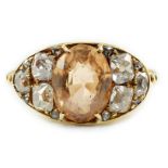 A 1940's gold and single stone oval cut orange topaz set ring, with six stone old mine cut diamond