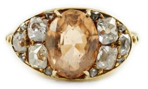 A 1940's gold and single stone oval cut orange topaz set ring, with six stone old mine cut diamond