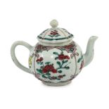 A Chinese famille rose petal lobed teapot, Yongzheng period, painted with panels of pinkish red