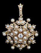 An Edwardian single stone diamond and seed pearl cluster set pendant brooch, of circular foliate