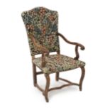 A Louis XIV walnut armchair, with arched needlework covered upholstered back and seat, scroll