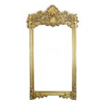 An ornate early 20th century carved giltwood wall mirror, with elaborate foliate scroll work top