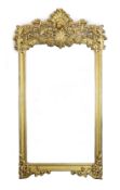 An ornate early 20th century carved giltwood wall mirror, with elaborate foliate scroll work top