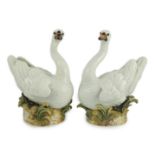 A pair of large Meissen models of swans, 19th century, each outside decorated, the swans seated on a