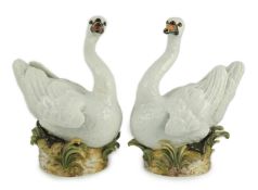 A pair of large Meissen models of swans, 19th century, each outside decorated, the swans seated on a