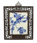 A Chinese blue and white wall plaque, late 19th century, painted with two birds perched in a peony