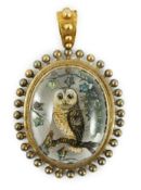 A Victorian yellow metal mounted Essex crystal oval pendant, depicting an owl upon a branch, amid