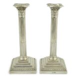 A pair of late Victorian silver Corinthian column candlesticks, by William Hutton & Sons, on stepped